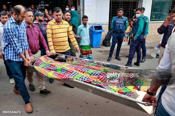 Relatives carry the body of a victim who died in a fire accident at a commercial building, to a morgue at the Dhaka Medical College hospital in Dhaka...