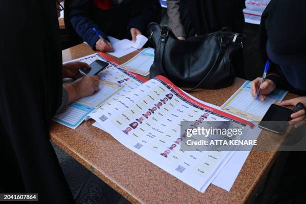 Iranian women fill out their ballots before casting their vote, during elections to select members of parliament and a key clerical body, in Tehran...