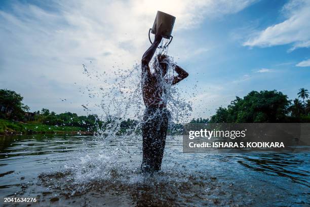 Man bathes along the backwaters of Kelaniya river, on a hot afternoon on the outskirts of Colombo on March 1, 2024.
