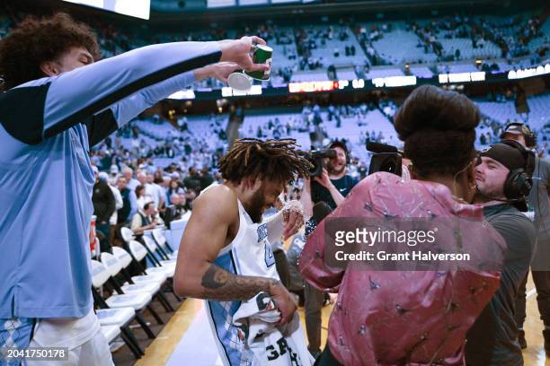 Zayden High douses teammate RJ Davis of the North Carolina Tar Heels after Davis' 42-point performance against the Miami Hurricanes during the game...
