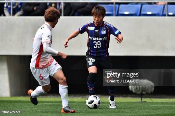 Jin Izumisawa of Gamba Osaka takes on Kazuya Miyahara of Nagoya Grampus during the J.League J1 match between Gamba Osaka and Nagoya Grampus at...