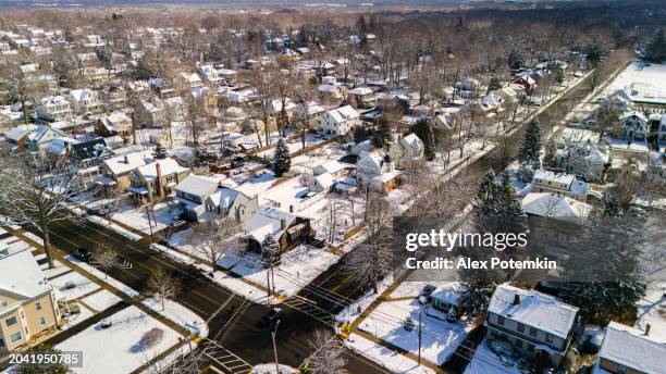 crossroad in winter madison, nj: greenwood ave is a snowy street with houses in small residential neighborhood - greenwood stock pictures, royalty-free photos & images