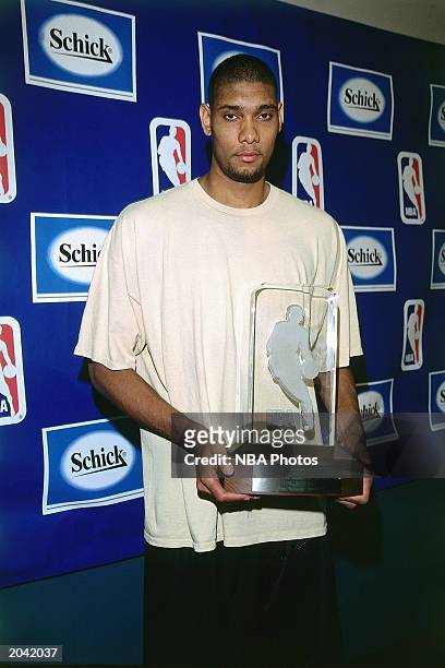 Tim Duncan of the San Antonio Spurs poses for a portrait after receiving the Rookie of the Year Trophy on April 27, 1998 in San Antonio, Texas. NOTE...