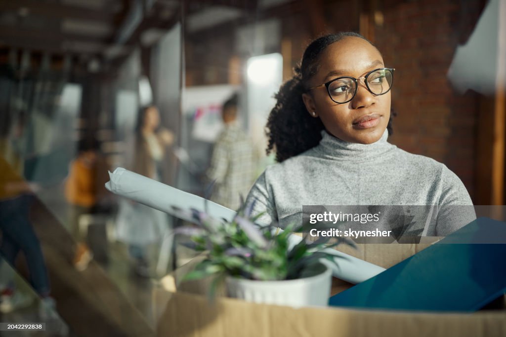 Worried black woman leaving the office after quitting a job.