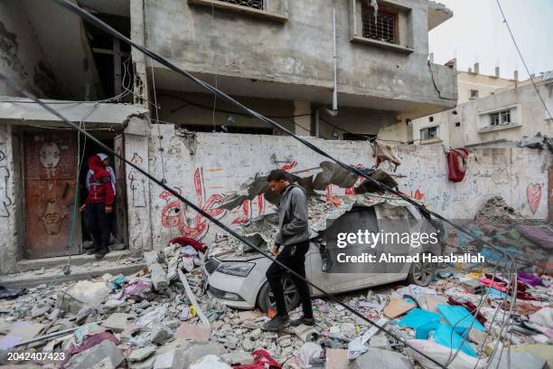 People inspect damage and recover items from their homes following Israeli air strikes on February 27, 2024 in Rafah, Gaza. As of Tuesday 878 had...