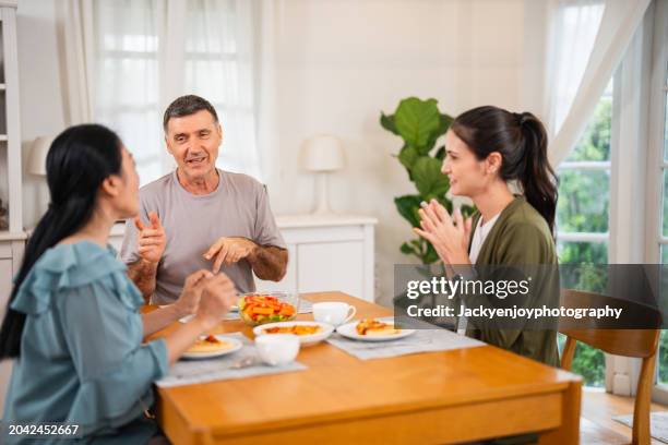 a young family having fun while having supper together and eating pizza - italian mother kitchen stock pictures, royalty-free photos & images