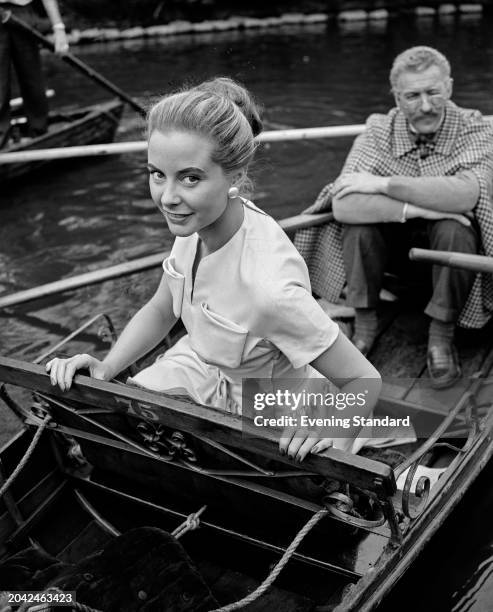 French actress Geneviève Page with David Niven , in stage makeup, during the filming of 'The Silken Affair', Regent's Park, London, May 8th 1956.