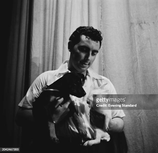 Magician David Berglas holding a puppy and a rabbit backstage at BBC's Lime Grove Studios, London, September 2nd 1955.