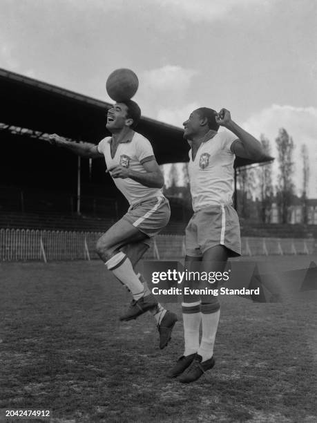 Brazilian footballers Nilton Santos and Djalma Santos heading and jumping for a ball at Dulwich Hamlet ground, London, during training ahead of an...