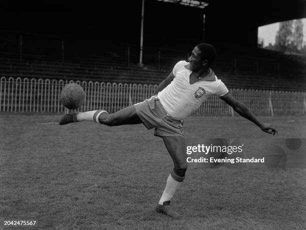 Brazilian football defender Djalma Santos kicking a ball on the side of his foot at Dulwich Hamlet ground, London, during training ahead of an...