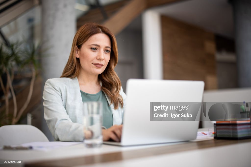 Successful businesswoman using laptop, working in office. Business technology corporate concept