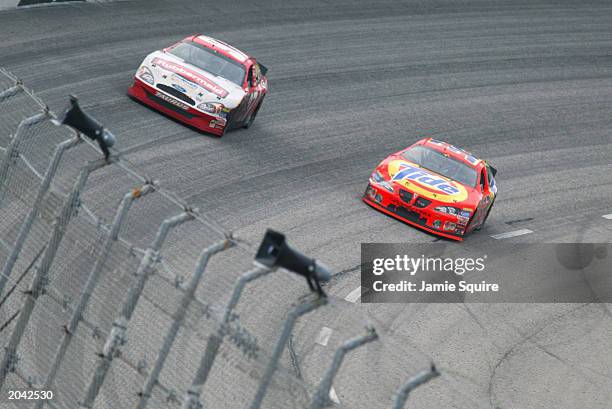 Eventual winner Ricky Craven, driver of the Tide Pontiac, passes Kurt Busch, driver of the Rubbermain Ford, on the final lap of the NASCAR Carolina...