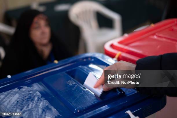 An Iranian man is casting his ballot at a polling station in downtown Tehran, Iran, on March 1 during the Parliamentary and Assembly of Experts...