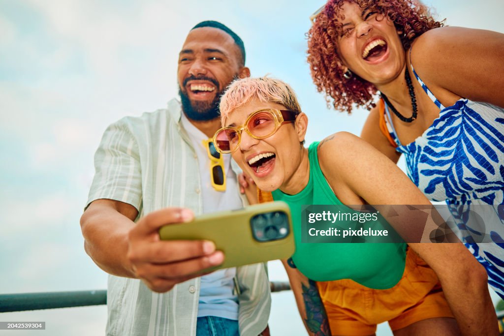 Happy group of friends using their smartphone while travelling.