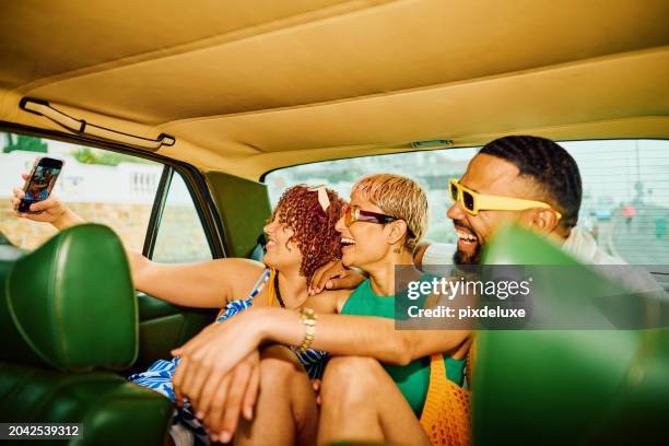 happy group of friends on the back seat of a car, getting away for the weekend. - car interior stock pictures, royalty-free photos & images