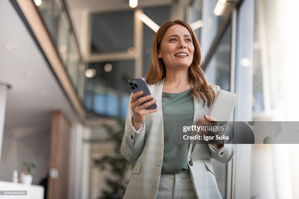 Smiling businesswoman using phone in office