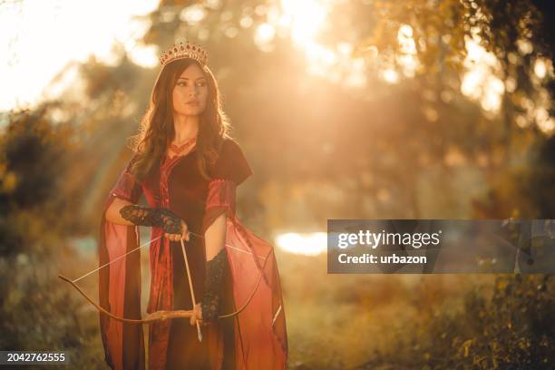 magical queen with a bow and arrow in the forest - evil queen stock pictures, royalty-free photos & images