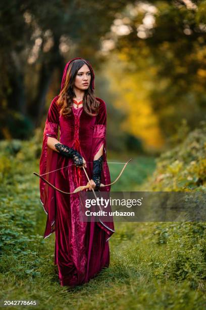magical woman with a bow and arrow in the forest - hunting longbow - fotografias e filmes do acervo