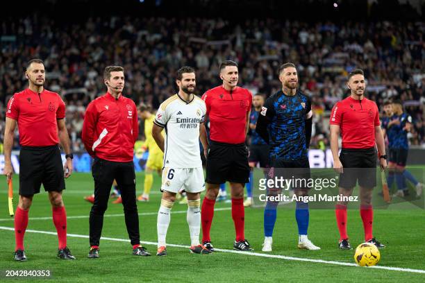 Captains Nacho Fernandez of Real Madrid and Sergio Ramos of Sevilla FC pose for a photograph with match officials prior to the LaLiga EA Sports match...