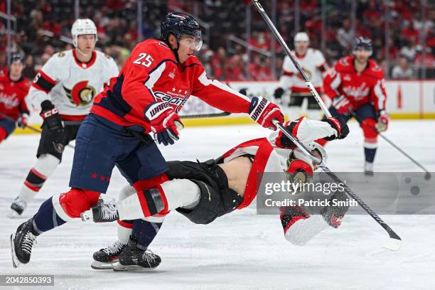 Ethan Bear of the Washington Capitals checks Ridly Greig of the Ottawa Senators during the first period at Capital One Arena on February 26, 2024 in...