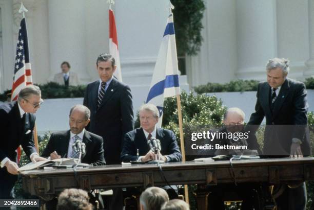 President Jimmy Carter with Egyptian President Anwar Sadat and Israeli Prime Minister Menachem Begin at the signing of the Camp David Accords Peace...