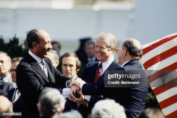 Egyptian President Anwar Sadat , President Jimmy Carter and Israeli Prime Minister Menachem Begin share a three way handshake after the signing of...