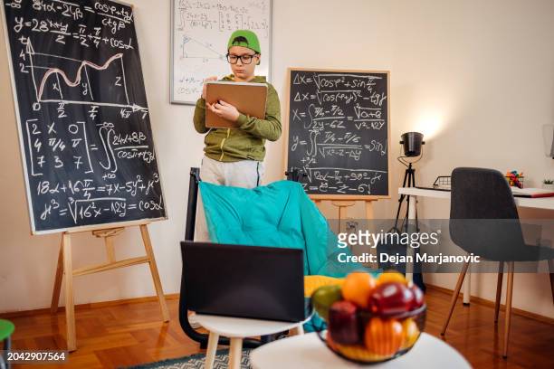 adolescent étudiant dur à la maison en écrivant quelque chose - boy in hard hat photos et images de collection