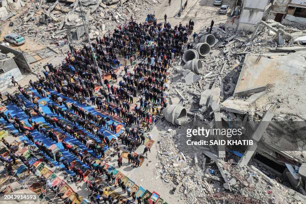 In this aerial view, Palestinians attend the Friday noon prayers in front of the ruins of the al-Faruq mosque, destroyed in Israeli strikes in Rafah...