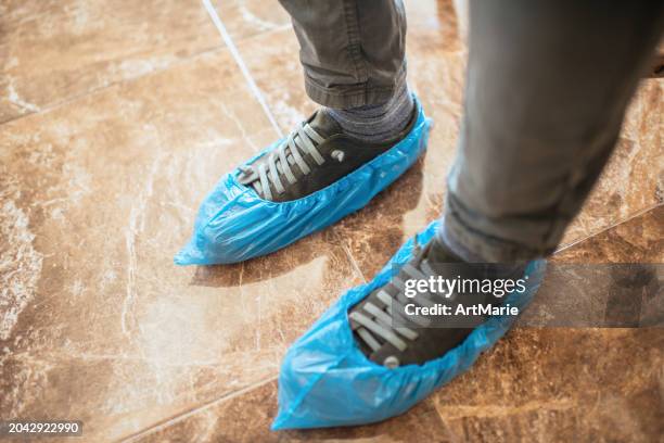 blue shoe covers on a man's shoes - medical shoe covers stock pictures, royalty-free photos & images