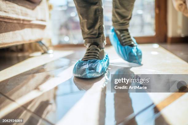 blue shoe covers on a man's shoes - medical shoe covers stock pictures, royalty-free photos & images