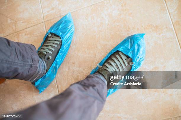 blue shoe covers on a man's shoes - medical shoe covers stock pictures, royalty-free photos & images