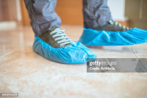 blue shoe covers on a man's shoes - medical shoe covers stock pictures, royalty-free photos & images