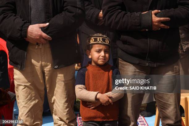 Palestinian boy looks on as people attend the Friday noon prayers in front of the ruins of the al-Faruq mosque, destroyed in Israeli strikes in Rafah...