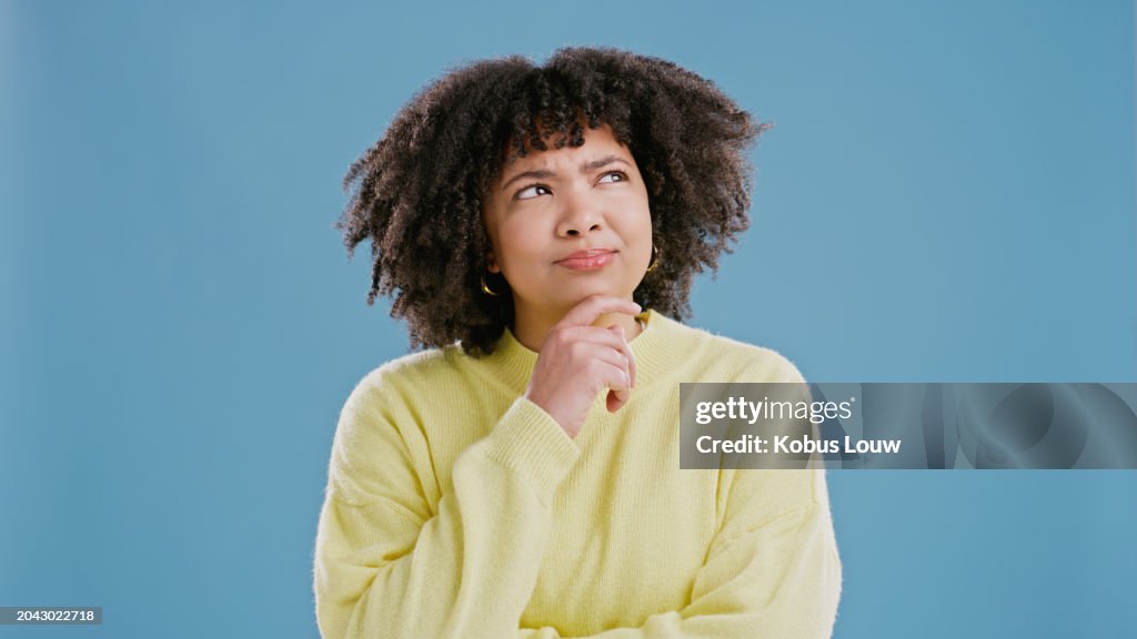 Mulher negra, maravilha e pensativa de ideia em estúdio para decisão, dúvida e contemplação para escolha. Pessoa feminina, curiosa e pensando em solução, fundo isolado e azul com pensamento profundo