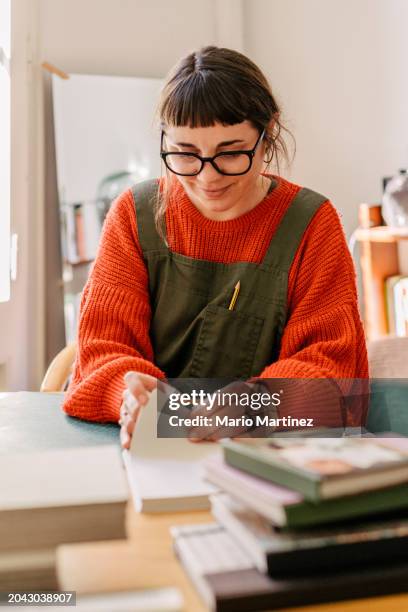 young woman working at home binding craft books - cutting mat stock pictures, royalty-free photos & images