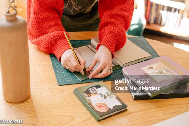 young woman working at home binding craft books - cutting mat stock pictures, royalty-free photos & images