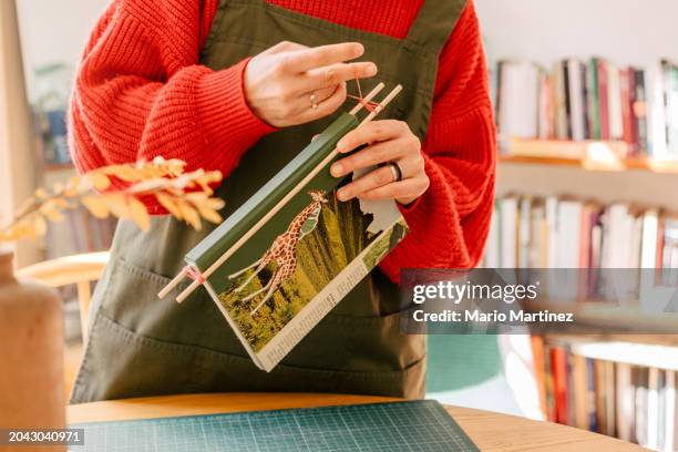 young woman working at home binding craft books - cutting mat stock pictures, royalty-free photos & images