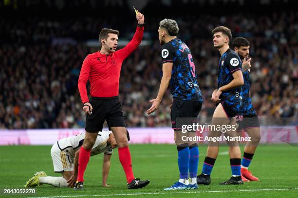 New Match Referee Carlos Fernandez Buergo shows a yellow card to Lucas Ocampos of Sevilla FC during the LaLiga EA Sports match between Real Madrid CF...