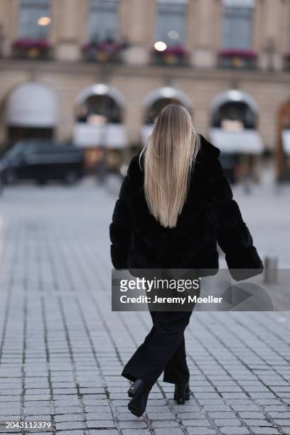 Andra Theobald seen wearing Glamify Fashion black fake fur short coat, NA-KD black straight leg suit pants and Louis Vuitton black leather heeled...
