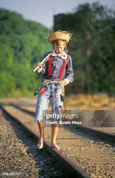 Huck Finn look-alike walks a railroad track during Tom Sawyer Days in Hannibal, Missouri, hometown of Tom Sawyer and Mark Twain , 2001. .