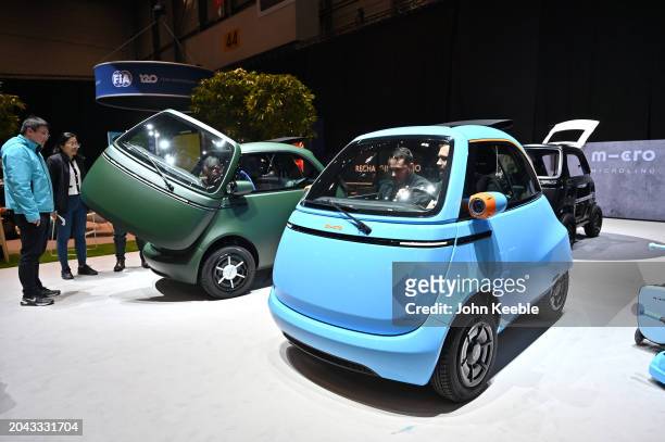 Visitors sit in a Microlino EV during the Geneva Motor Show 2024 at Palexpo on February 26, 2024 in Geneva, Switzerland. The 2024 Geneva Motor Show...