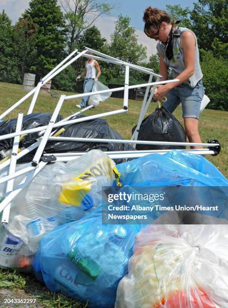 Anna Marie Wright of Boone, N.C. Helps clean up trash left behind from campers who attended the Camp Bisco music festival Monday, July 16, 2012 in...
