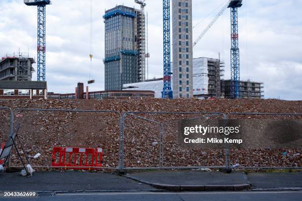 View looking across a demolition site piled high with rubble and red bricks towardsnew high rise tower blocks under construction on 26th February...