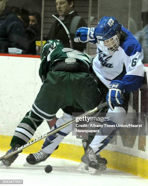 From left, Shenendehowa's Ryan Mortka battles for the puck with Saratoga's Matt Flynn during the section II division I hockey championship game at...