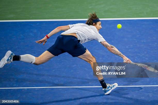 Alexander Bublik of Kazakhstan hits a return against Russia's Andrey Rublev during their semi-final match at the ATP Dubai Duty Free Tennis...