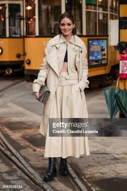 Olivia Palermo wears beige leather jacket with matching beige midi skirt, beige trench coat, taupe Tod's bag, black boots, outside Tod's, during the...