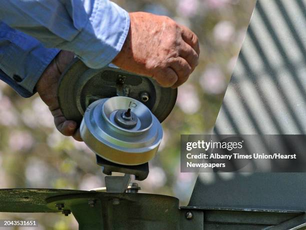 Larry Syzdek, an aerobiologist who counts pollen for a national database, uses a scientific vacuum called a Burkard at his pollen station at his farm...