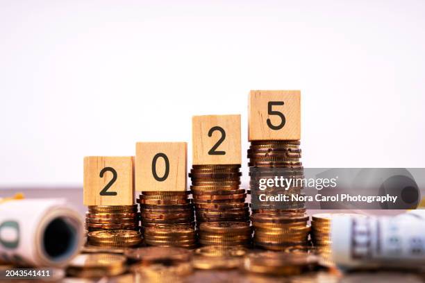 new year 2025 on wood block with stack of coins - neujahrsvorsatz stock-fotos und bilder