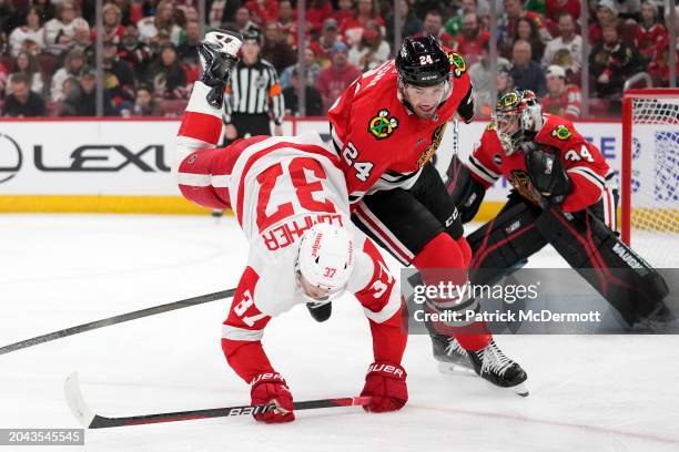 Compher of the Detroit Red Wings is upended by Jaycob Megna of the Chicago Blackhawks during the first period at the United Center on February 25,...