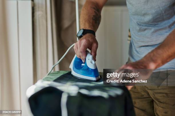 clothes, iron and hands of man with shirt getting ready in morning for fresh, neat and clean clothing. housework, laundry and male by ironing board for cleaning, hygiene and domestic lifestyle - tábua-de-passar-roupa imagens e fotografias de stock